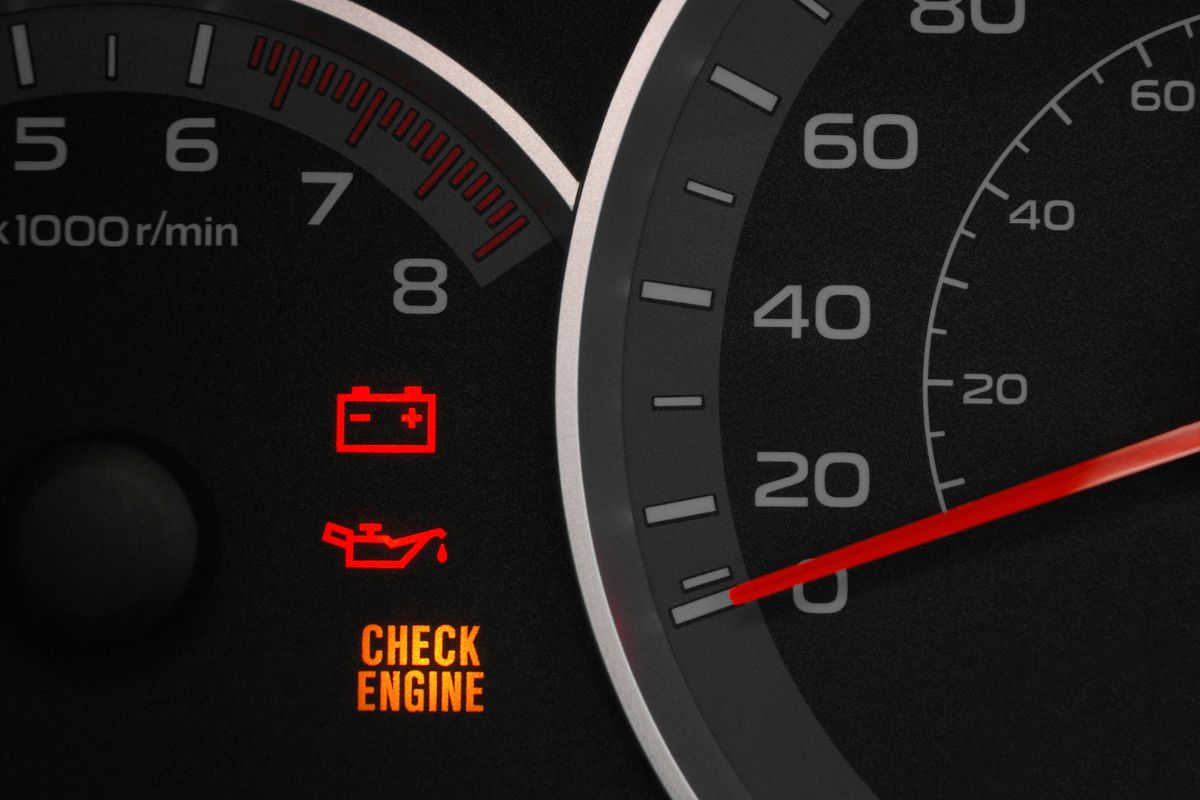 check engine warning light glowing on car dashboard