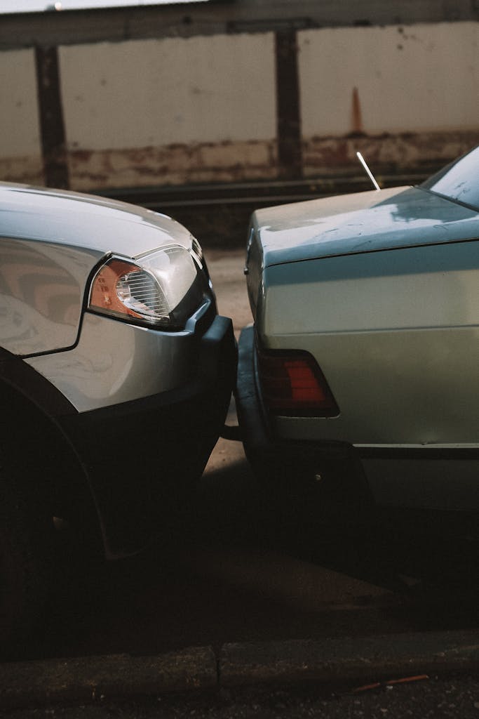A close-up view showing the aftermath of a rear-end car collision in an outdoor setting.